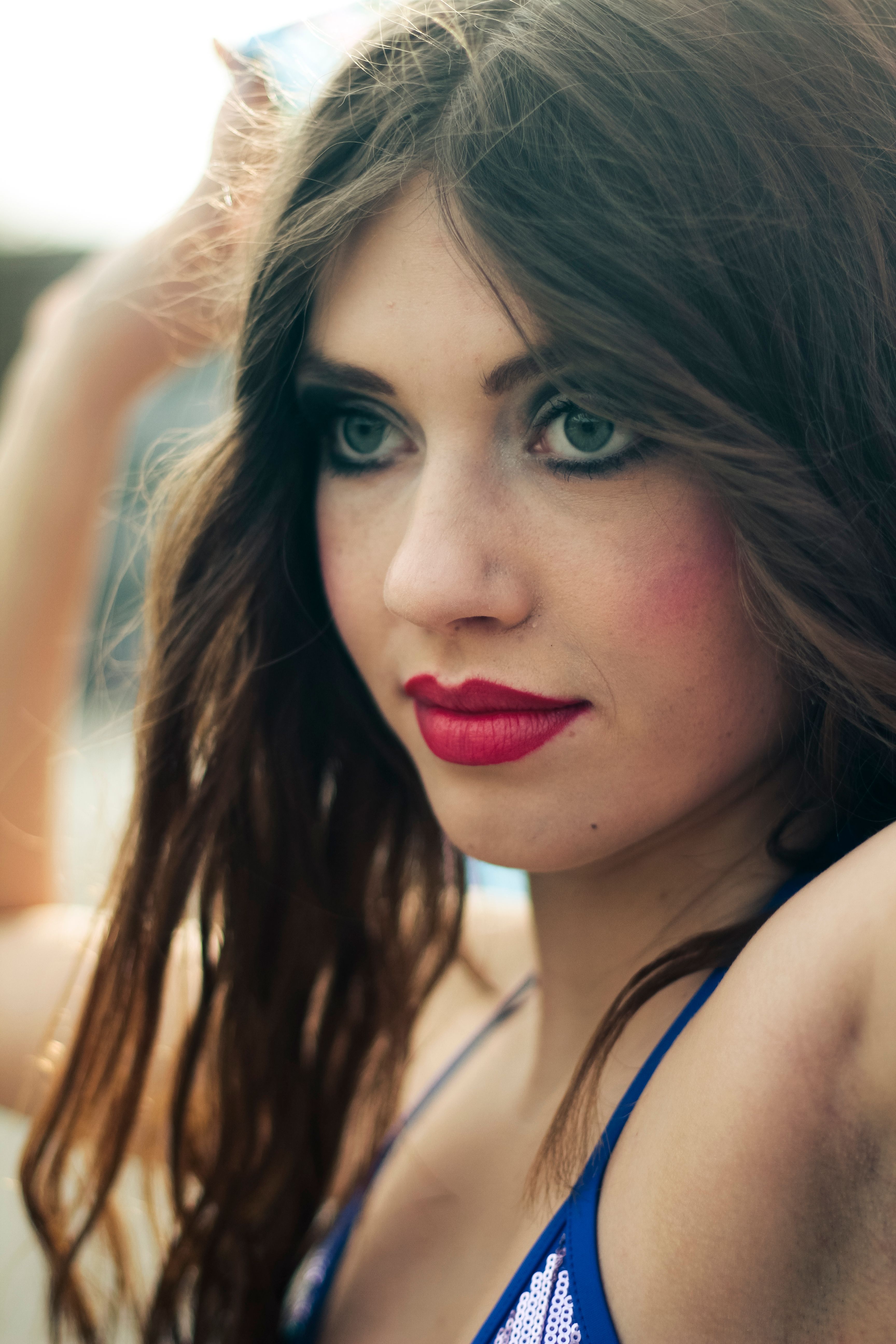Elegant close-up portrait focusing on a young woman's red lips and captivating blue eyes.