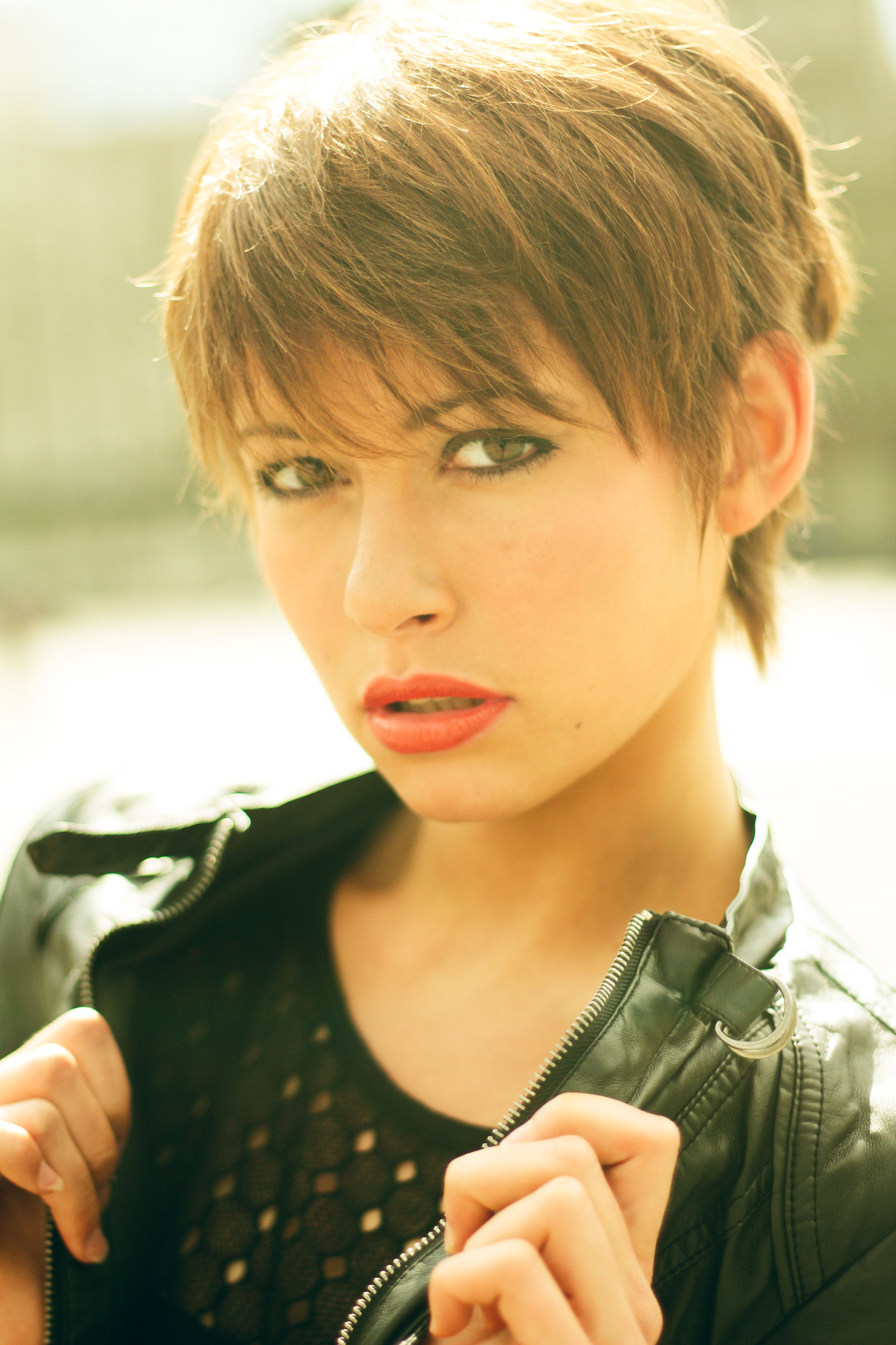 Elegant portrait of a young woman in a leather jacket, captured outdoors in Hamburg.