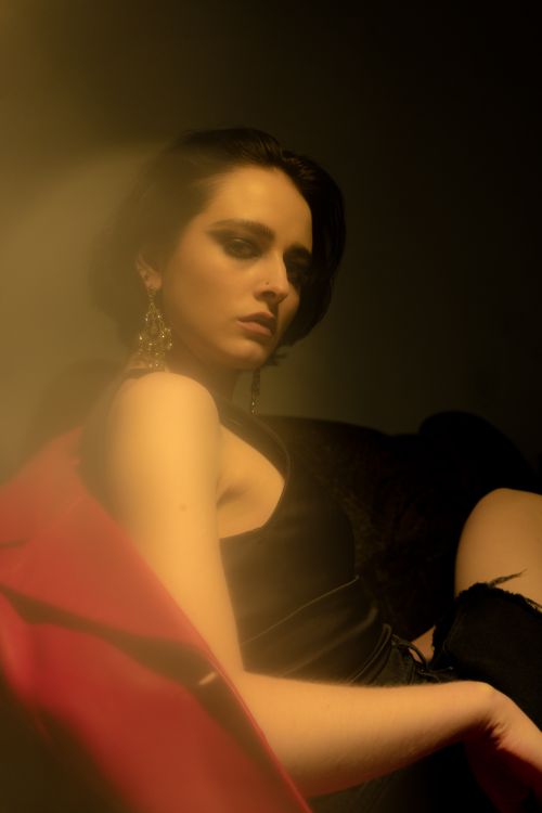 Free Side view of slender eccentric female with short dark hair looking at camera while resting Stock Photo