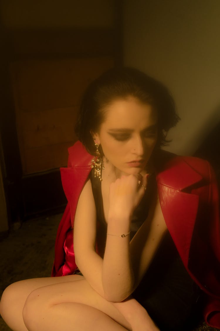 Alluring Thoughtful Woman In Elegant Red Jacket Pondering