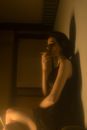 Side view of extravagant female with eyes closed and cigarette resting while leaning on wall
