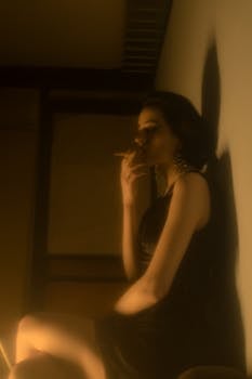 Side view of extravagant female with eyes closed and cigarette resting while leaning on wall