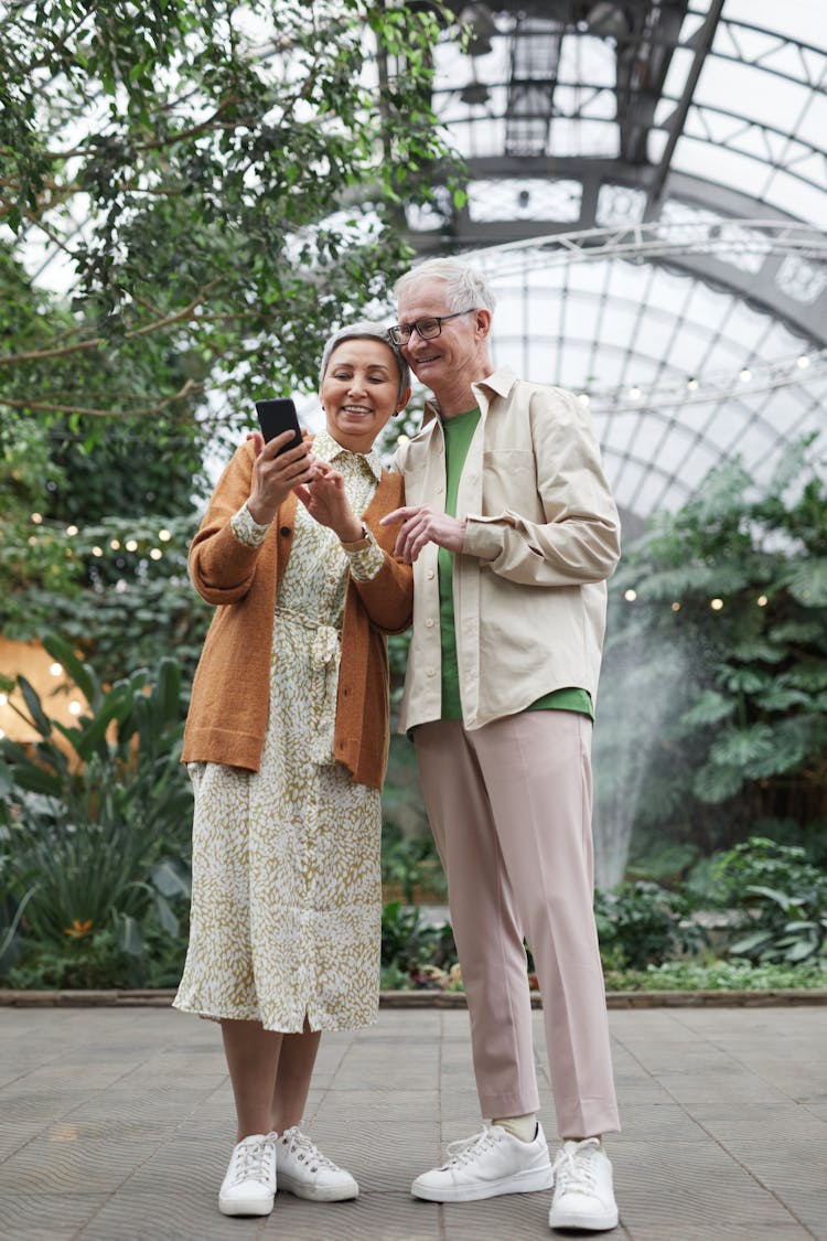 Couple Smiling While Looking At A Smartphone