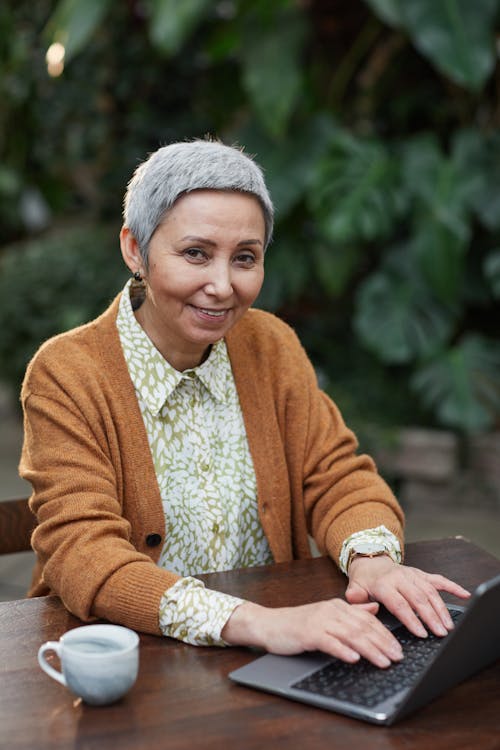 Woman Smiling While Using Her Laptop