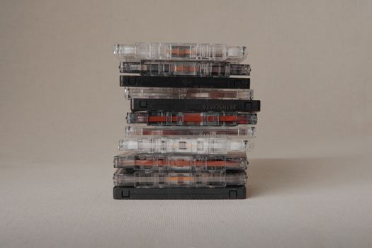 Close-up of stacked cassette tapes against a neutral backdrop, capturing an iconic retro vibe.