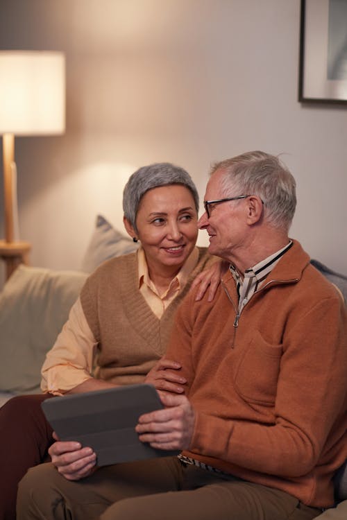 Free Man and Woman Sitting on Sofa While Looking at Each Other Stock Photo