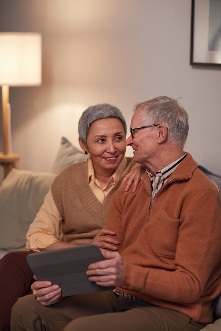 Man And Woman Sitting On Sofa While Looking At Each Other