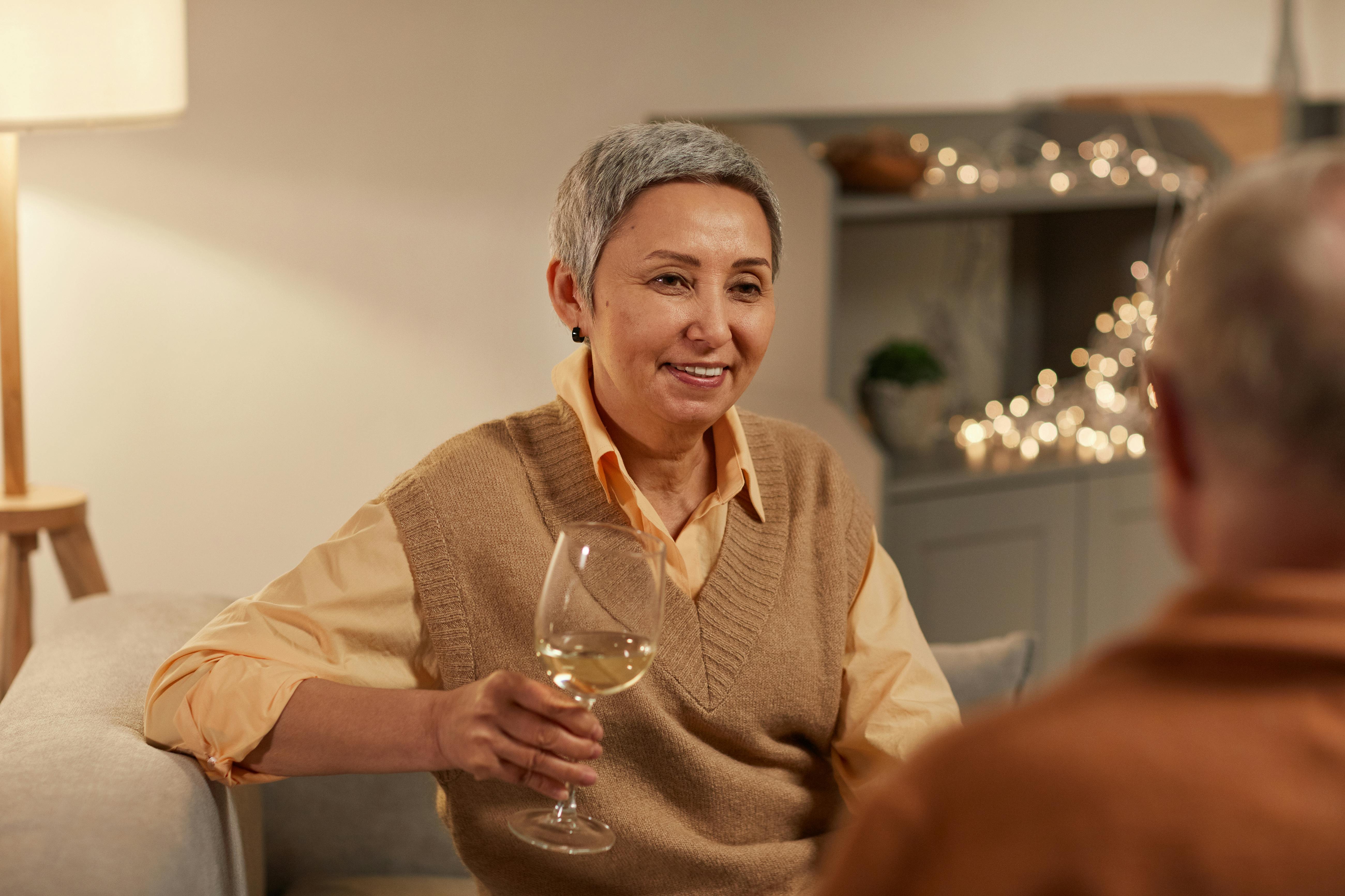 woman smiling while holding wine glass