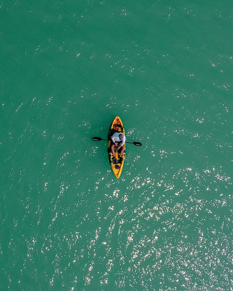 Vista aérea de persona en kayak hinchable en el mar turquesa