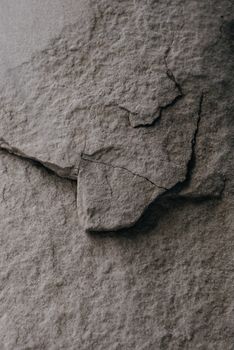 Texture and natural wear of a vertical concrete wall with visible cracks, perfect for backgrounds or material studies.