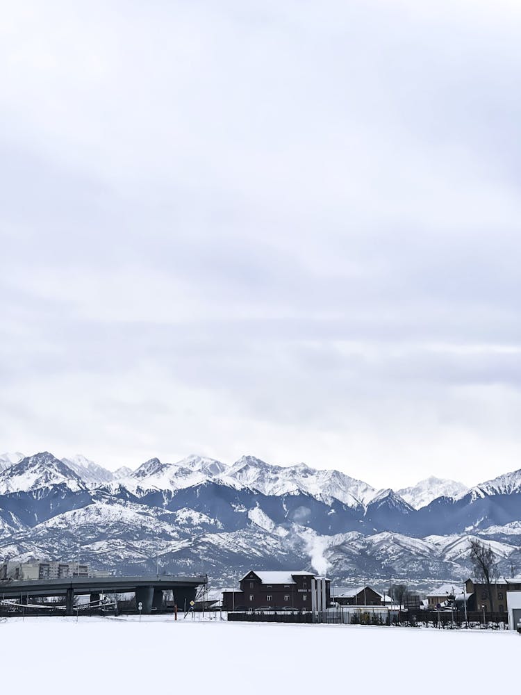 Village Near To Bridge Against Mountains In Winter