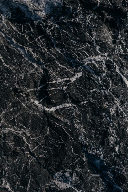 Free A detailed view of a dark marble surface with intricate white veining patterns. Stock Photo