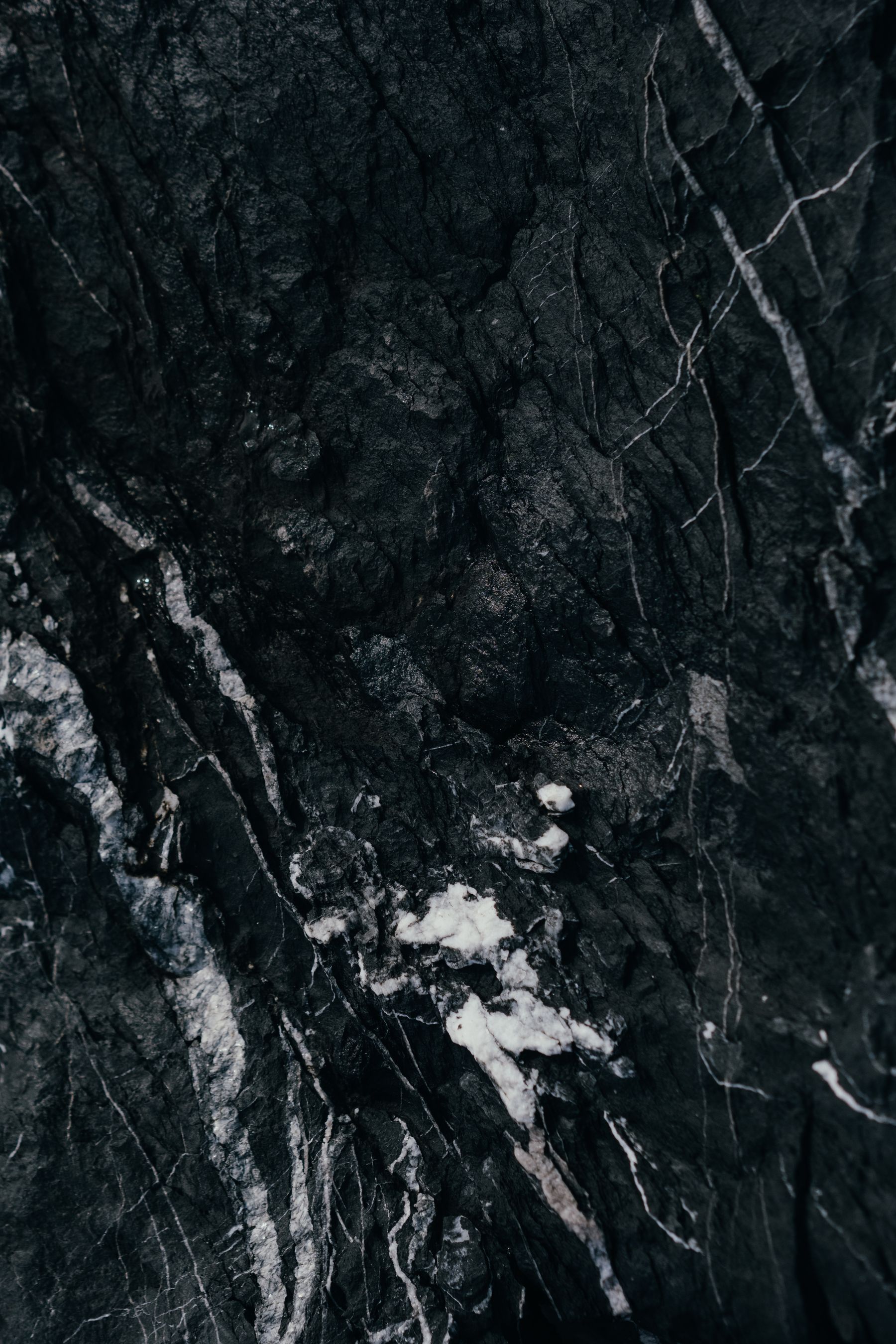 A slab of dark marble crossed by pale veins