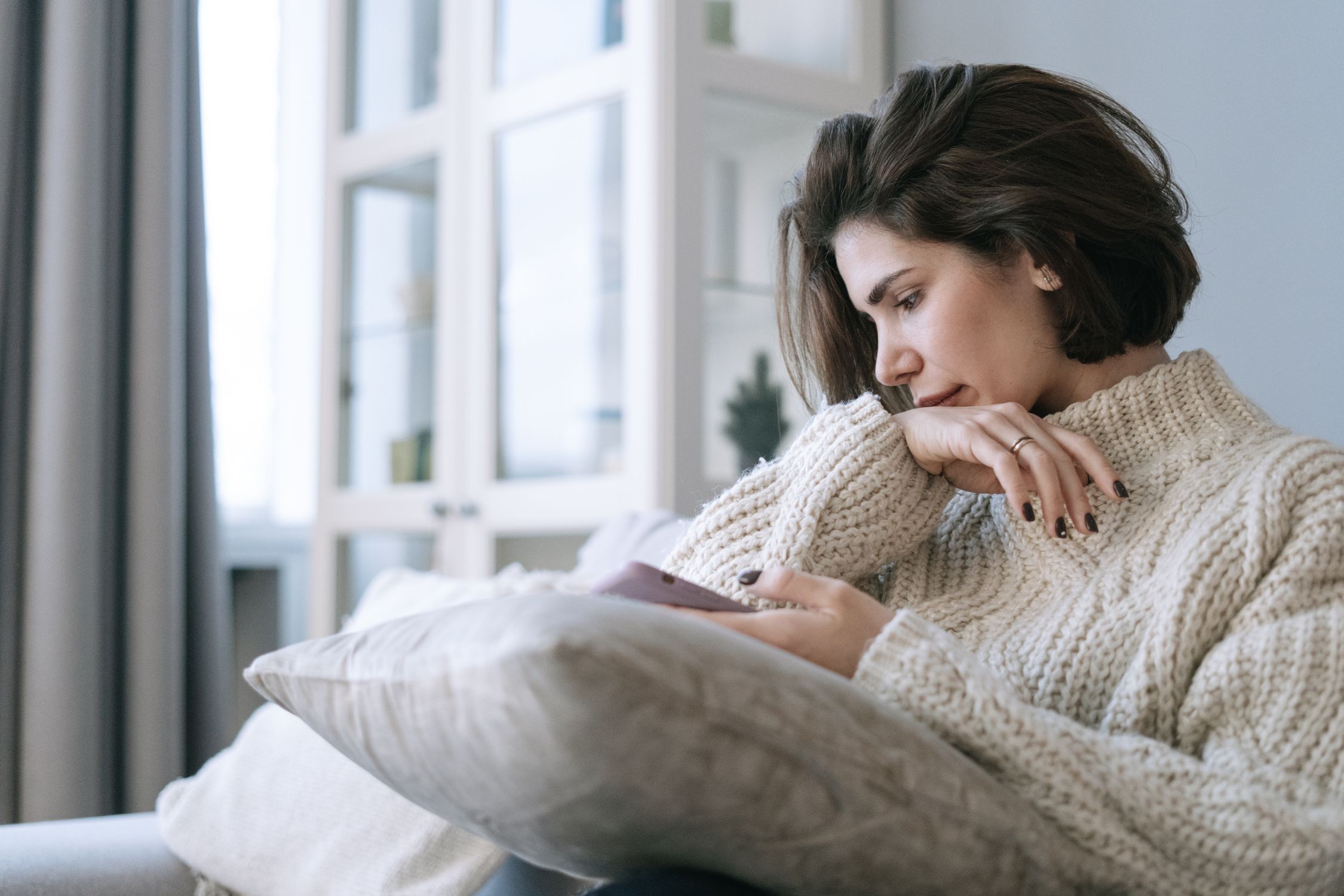 Mulher em momento introspectivo, lidando com a sobrecarga de comparação social e monitoramento emocional digital.