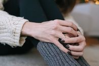 Person in Gray Sweater Holding Black Textile
