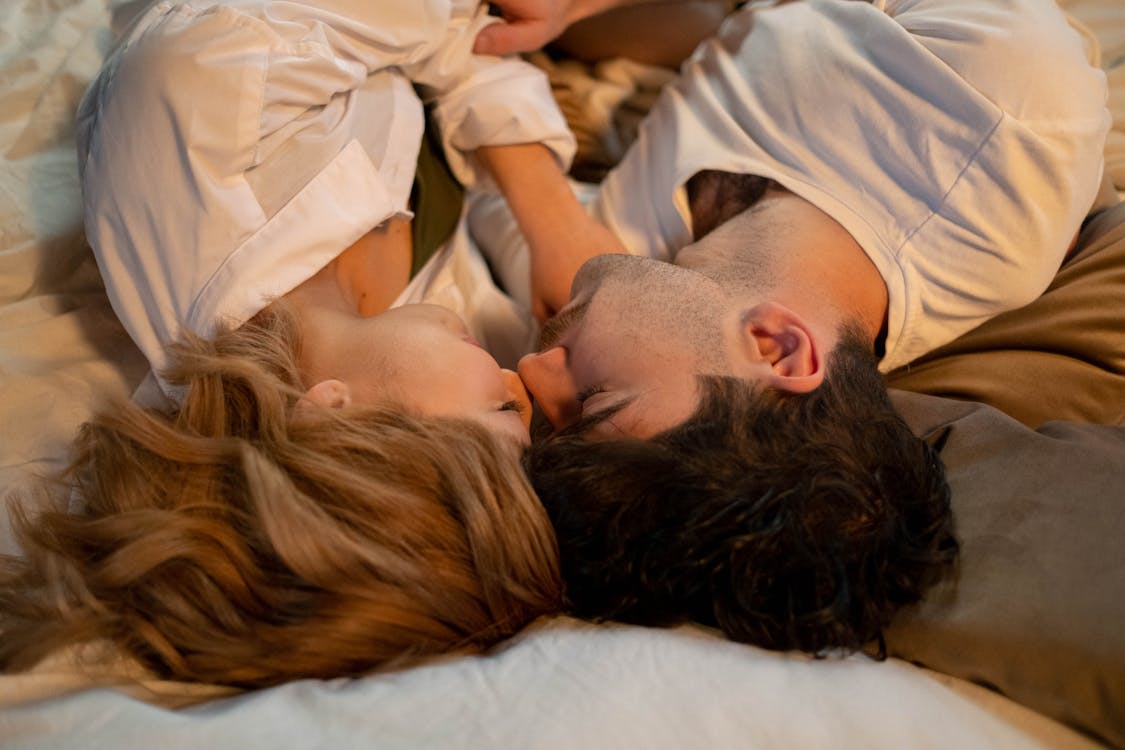 Free A Romantic Couple Lying on the Bed Stock Photo