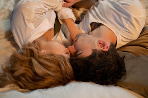 Free A Romantic Couple Lying on the Bed Stock Photo