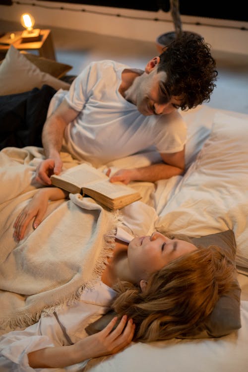 Free A Romantic Couple Lying on the Bed Stock Photo