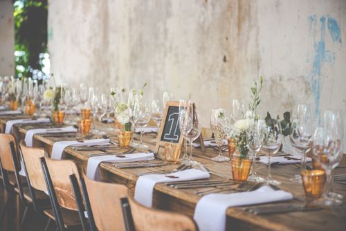 Free Rustic wooden table set for a celebration with flowers and glassware. Stock Photo