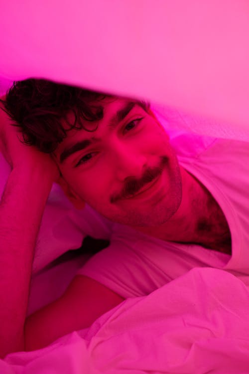 A Man Smiling while Under the Blanket
