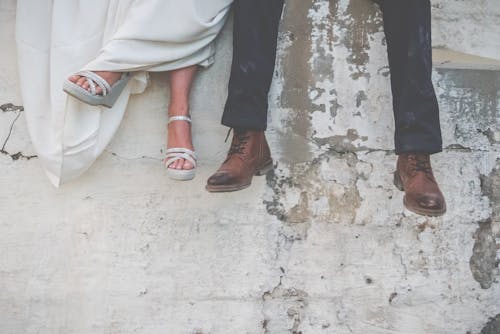 A Man and Woman's Feet in Boots and Heels 