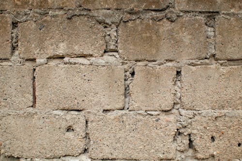 Brick uneven wall of building in street
