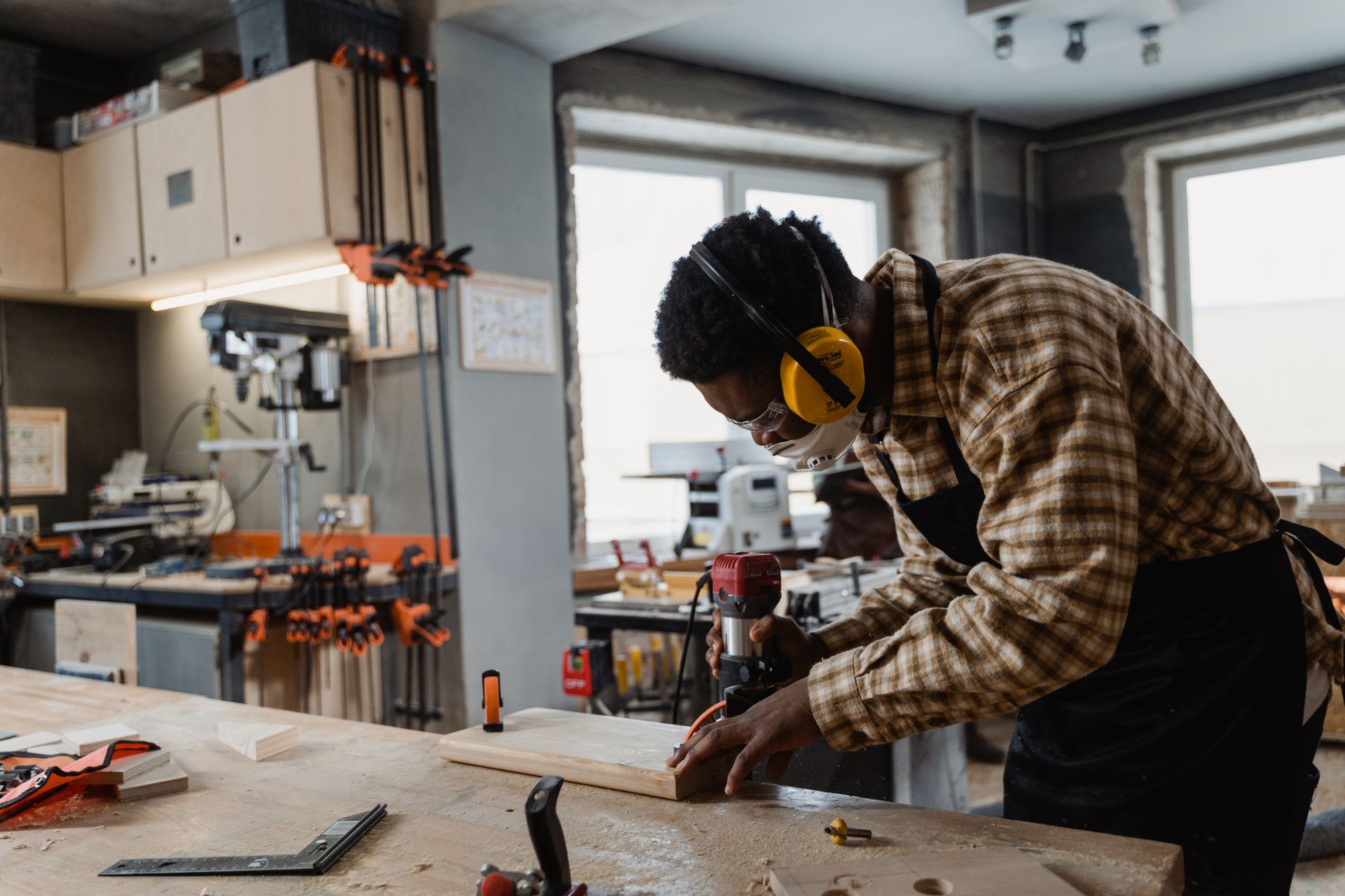 A craftsman working intently with woodworking tools at a bench