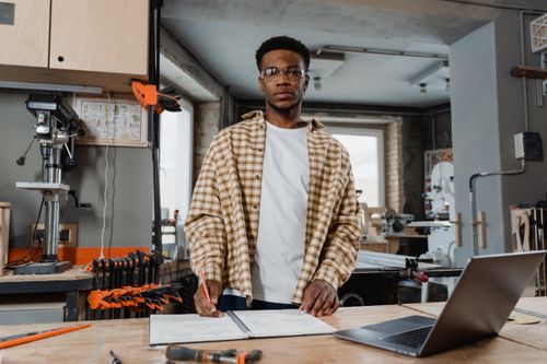 Free Professional woodworker in workshop, crafting plans with tools, showcasing woodworking skills. Stock Photo