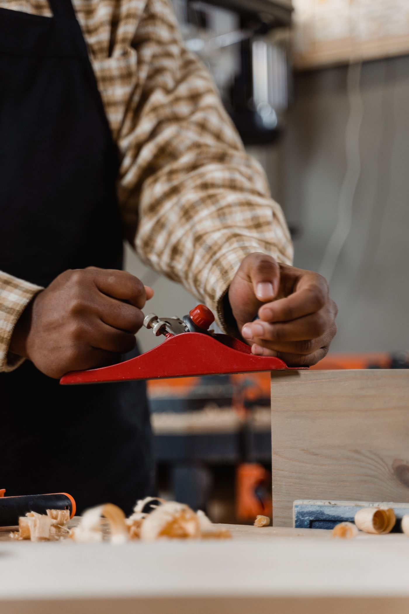 Craftsman hand-planing a piece of wood in a workshop