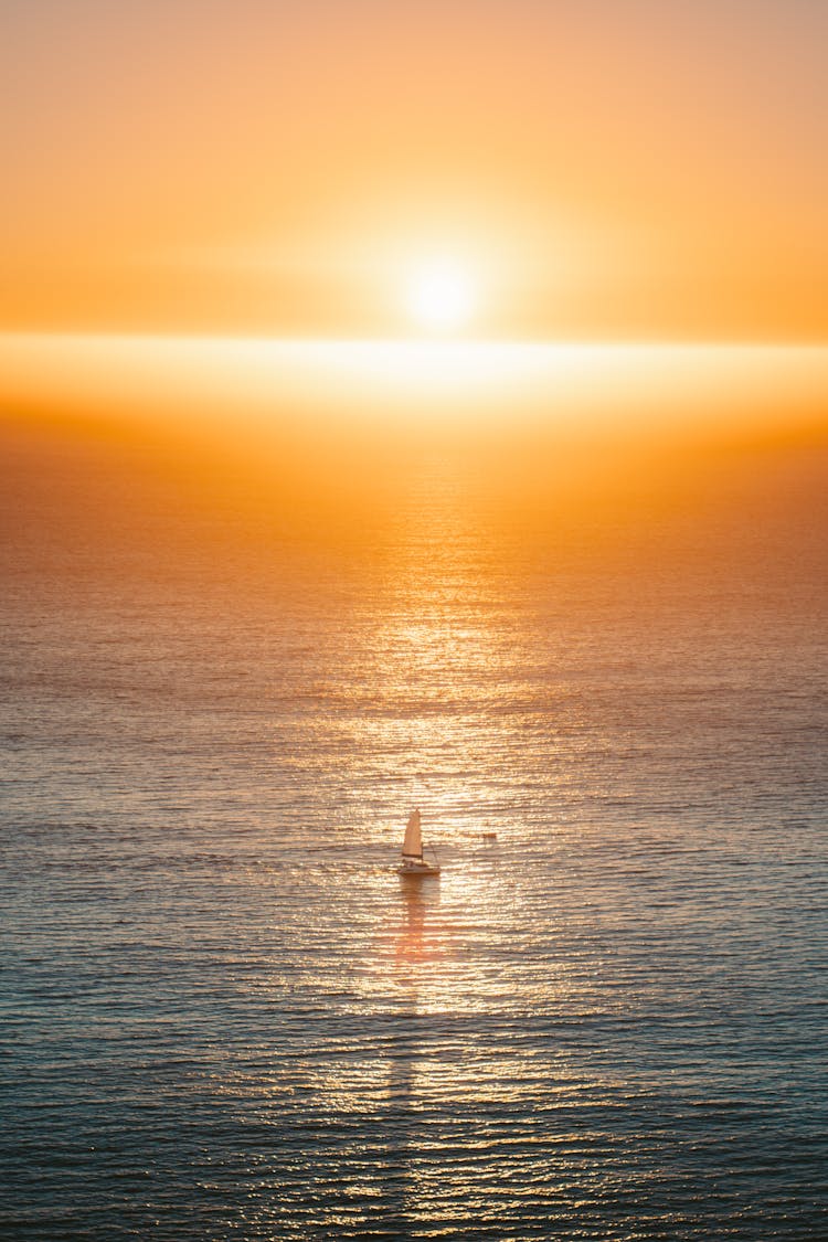 A Sailboat Sailing During Sunset