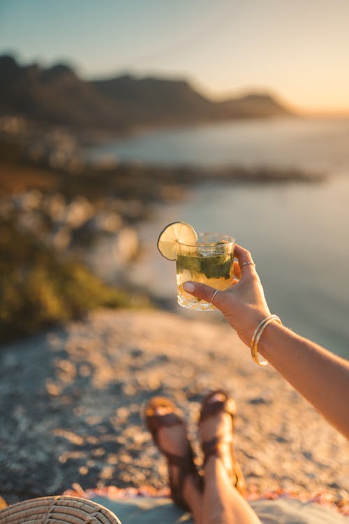 Selective Focus Photo of a Person's Hand Holding a Mojito Drink