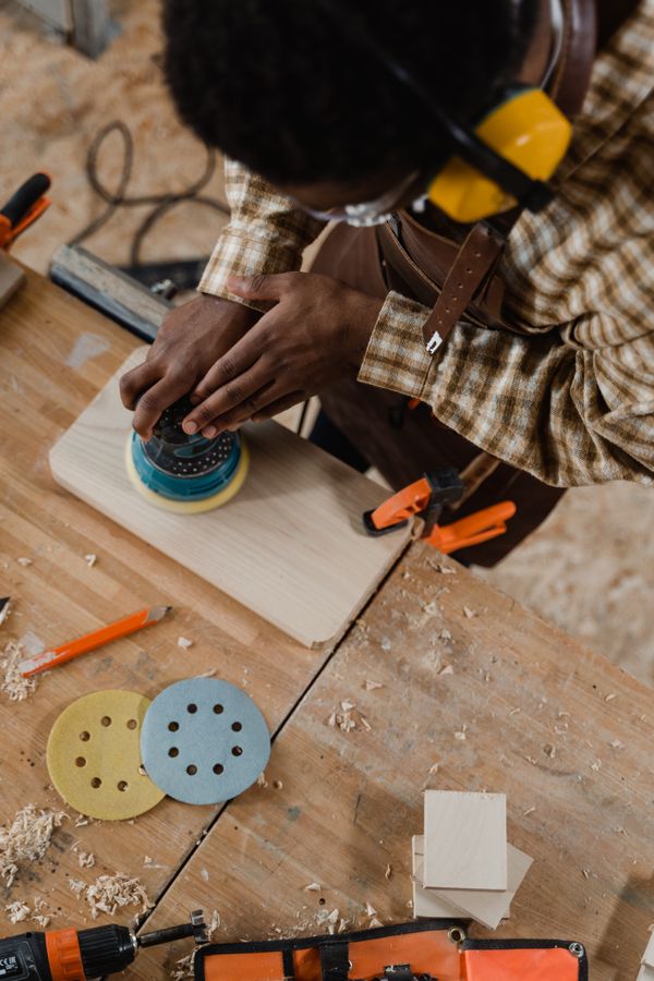Orbital sander finishing a piece of wood