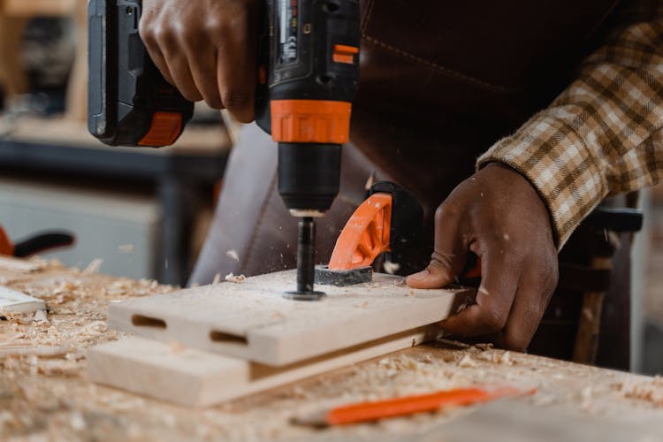 Carpenter Drilling A Wood