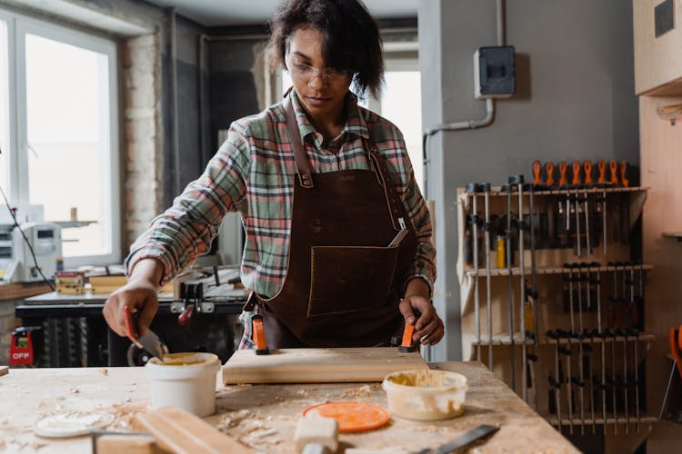 Woman Putting Wood Glue On A Plank