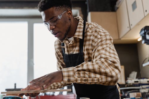 A Man Working in the Workshop Wearing Protective Goggles