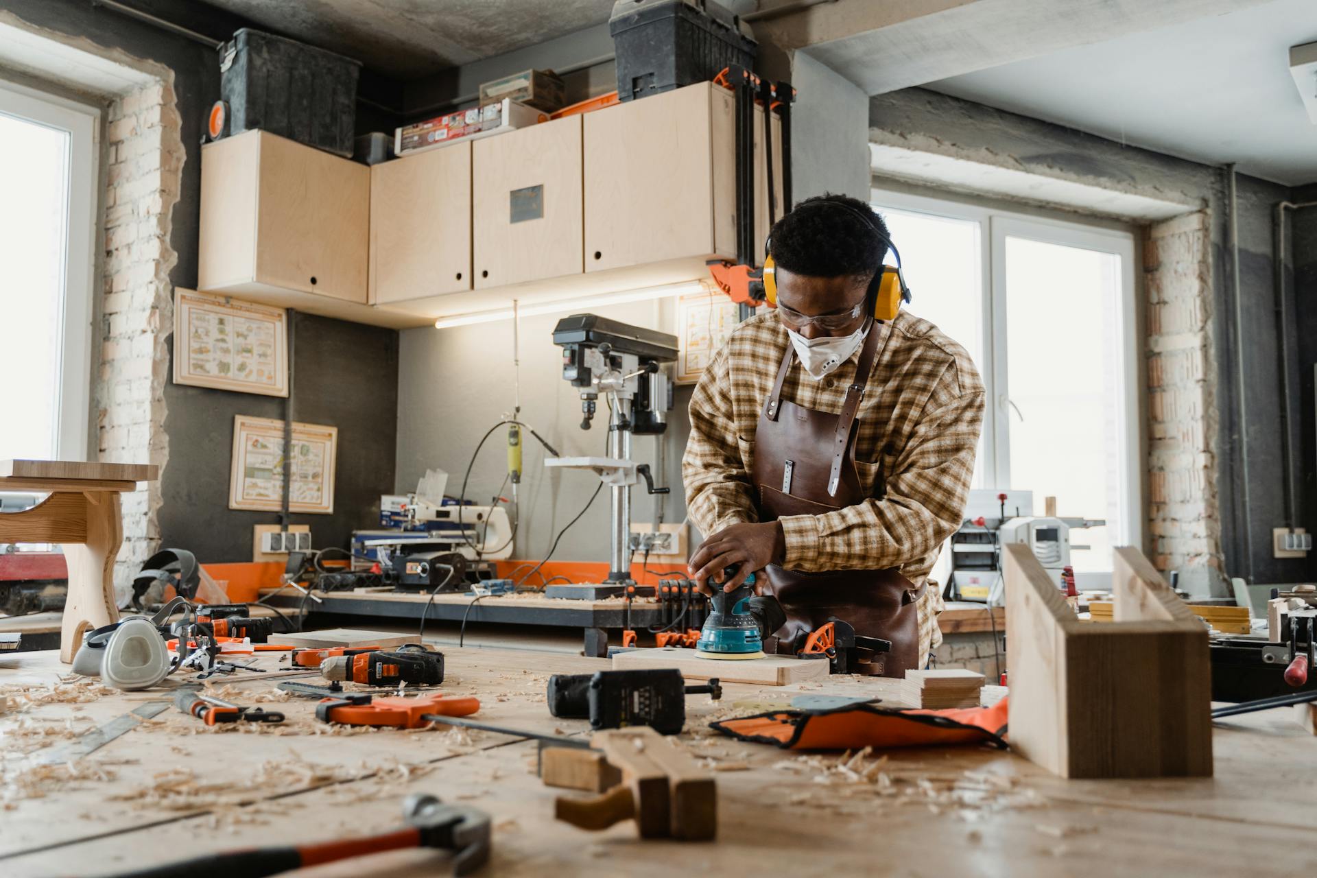 A skilled craftsman working with tools in a well-equipped woodworking workshop.