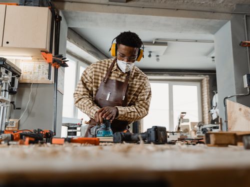 Free Craftsman working with tools in a well-lit workshop, focusing on carpentry skills. Stock Photo