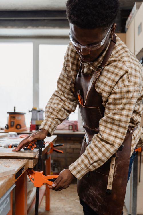 Free A craftsman focuses on precise woodworking in a well-equipped workshop. Stock Photo