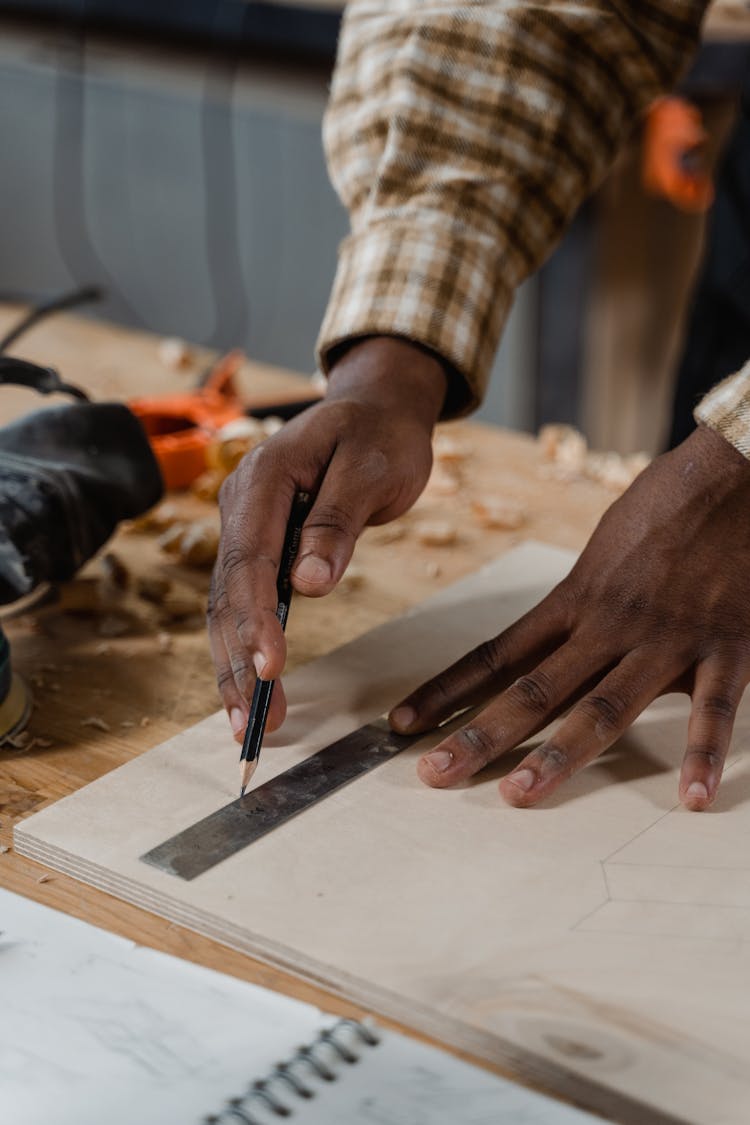 Close-up Of Person Measuring A Wood Using A Ruler