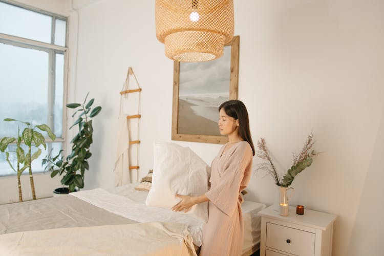 Woman Holding A Pillow Inside The Bedroom