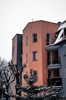 Colorful apartment building with snowy surroundings, showcasing architectural design.