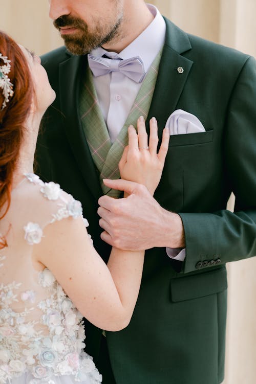 Free A Man in Suit Holding The Hand of a Person in White Top Stock Photo