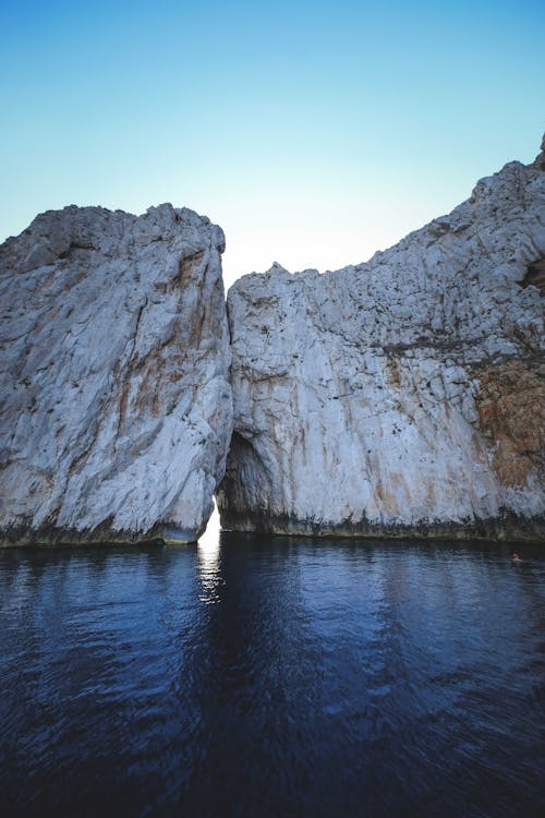 Rocky cliffs forming natural arch in sea