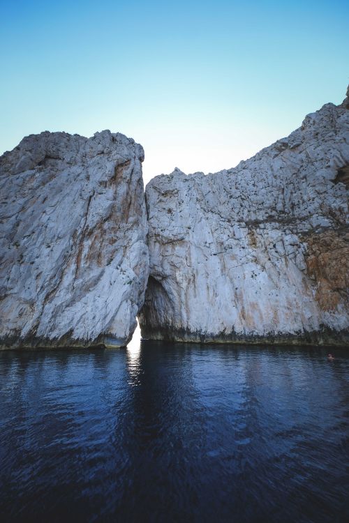Free Amazing scenery of natural arch between chalk cliffs in sea water against cloudless blue sky on sunny day Stock Photo