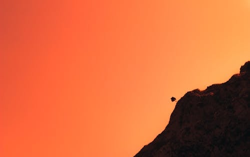 Silhouetted Side of a Rocky Mountain against a Pink Sunset Sky 