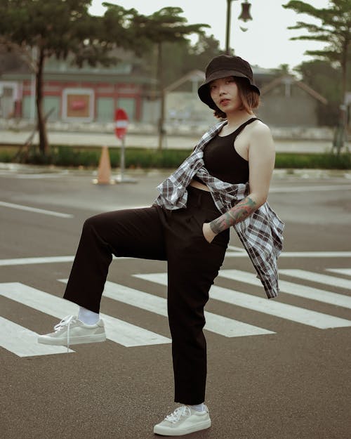 Serious ethnic woman with hands in pockets on road