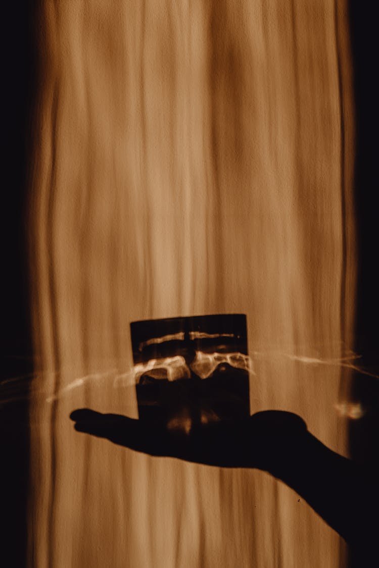 Silhouette Of Woman Hand Holding Candle