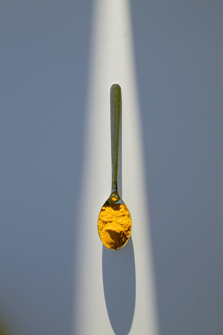 Metal Spoon With Yellow Seasoning