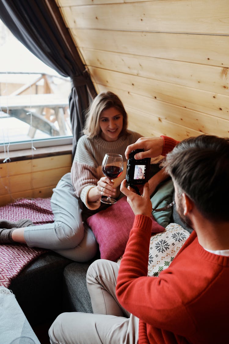 Man Taking Photo Of Girlfriend Drinking Wine