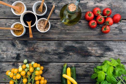 Top view of fresh vegetables and spices for salad placed on wooden table in daytime